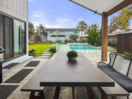 a wooden table with a potted plant on a patio at Private Coastal Oasis - Long Jetty in Long Jetty