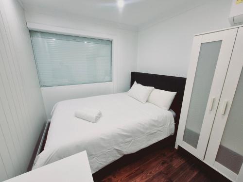 a small bedroom with a white bed and a window at Kaban Power 39 in Bidwill