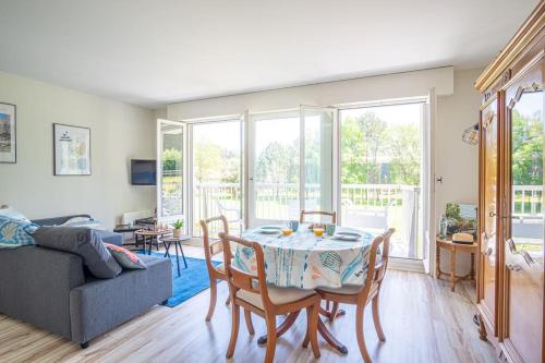 un salon avec une table et des chaises dans l'établissement Calme et sérénité - Balcon - Parking 1 place, à Étretat