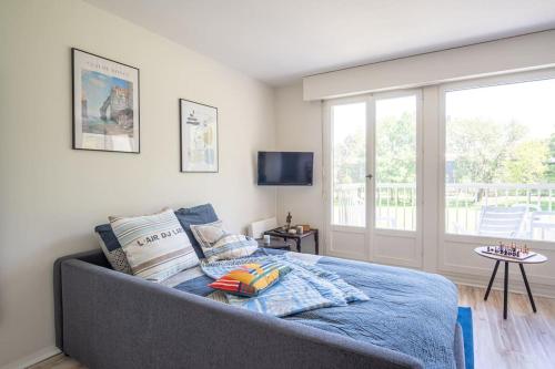 une chambre avec un lit et une grande fenêtre dans l'établissement Calme et sérénité - Balcon - Parking 1 place, à Étretat