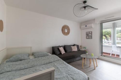 - une chambre blanche avec un lit et un canapé dans l'établissement Port et Centre ville Climatisation Piscine au sein de la résidence Port, à La Grande Motte
