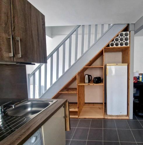 d'une cuisine avec un escalier et un réfrigérateur blanc. dans l'établissement Proche Bordeaux centre : petite maison de ville +parking, à Cenon