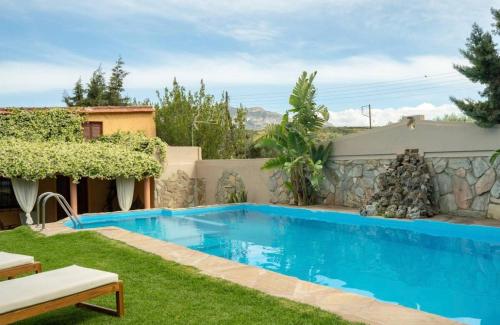 a swimming pool in the yard of a house at DM Elegant and Charming Villa in Foinikiá