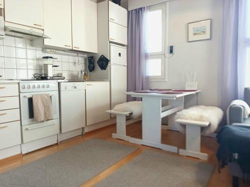 a kitchen with a white table and a table and a table at Puistokatti Apartment in Vuokatti