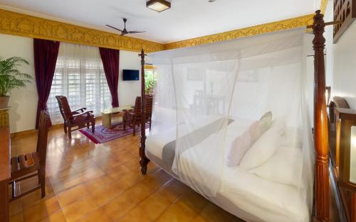 a bedroom with a bed with a canopy at Bethsaida Hermitage in Kovalam