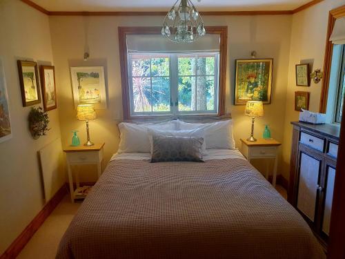 a bedroom with a large bed with a window at Bumblebee Cottage in Greytown