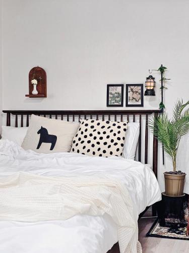 a bedroom with a white bed with a black and white comforter at Seoul 리베하우스 3room KSPO-DOM Family trip in Seoul