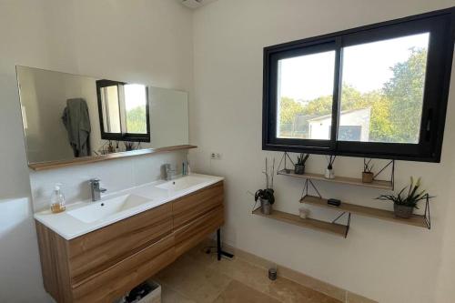 une salle de bain avec un lavabo, un miroir et une fenêtre dans l'établissement Maison contemporaine 180m2 entre Avignon & Nîmes, à Rochefort-du-Gard
