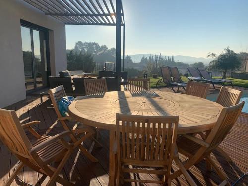 une table et des chaises en bois sur une terrasse dans l'établissement Maison contemporaine 180m2 entre Avignon & Nîmes, à Rochefort-du-Gard