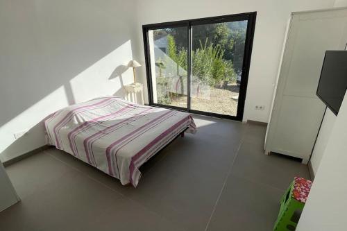 une chambre avec un lit et une grande fenêtre dans l'établissement Maison contemporaine 180m2 entre Avignon & Nîmes, à Rochefort-du-Gard