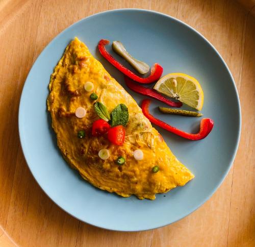 a plate with a piece of omelet with red peppers at SeidenStrasse Pension in Mölln