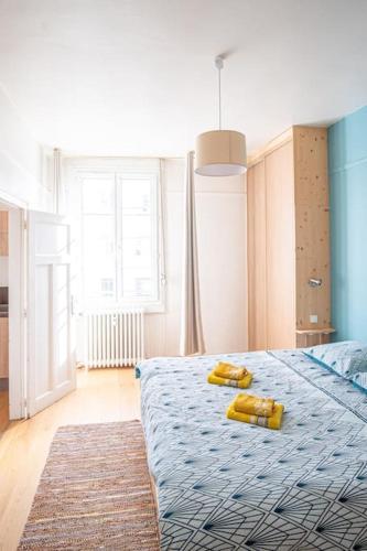 - une chambre dotée d'un lit avec deux objets jaunes dans l'établissement O Petit Franklin - Palais de Justice - Tram, au Havre