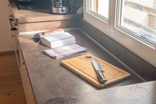une planche de découpe et un couteau sur un comptoir dans l'établissement O Petit Franklin - Palais de Justice - Tram, au Havre