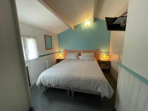 une chambre avec un lit avec deux oreillers dans l'établissement Villa située entre mer et forêt, à Grand-Village-Plage