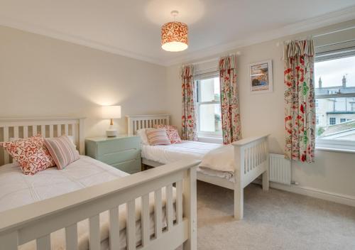a bedroom with two beds and a window at Tucked Away Cottage in Seaton