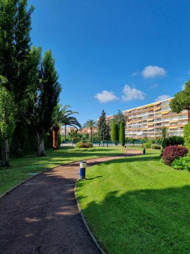 a path in a park next to a building at Studio lumineux piscine/plages in Mandelieu-la-Napoule