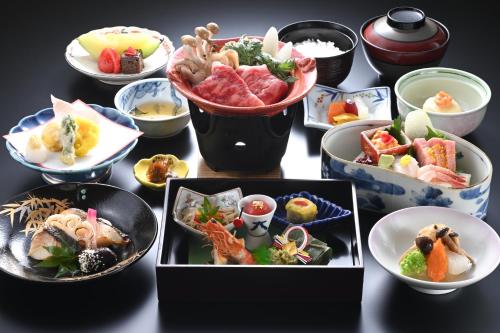 un grupo de platos de comida en una mesa en Osakaya Ryokan, en Kusatsu