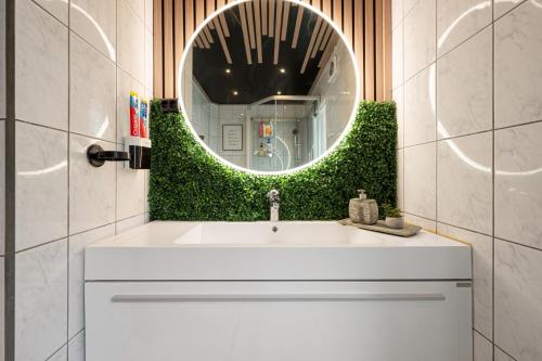 a bathroom with a white sink and a mirror at AA Home Solgryveien Harstad in Harstad