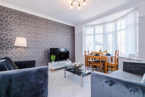 a living room with a couch and a dining room at "Eastville Court Rhyl" by Greenstay Serviced Accommodation - Cosy 2 Bedroom Bungalow with Parking, Netflix & Wi-Fi, Close To Beaches, Shops & Restaurants - Ideal for Families, Business Travellers & Contractors in Rhyl
