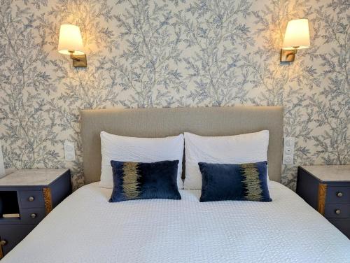 a bedroom with a bed with two blue pillows at LE CEMAROSE Cottage & Spa Terrace Garden & lovely View in Épernay