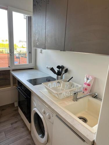 une cuisine avec un évier et une machine à laver dans l'établissement Charmant Studio équipé à Nice, à Nice