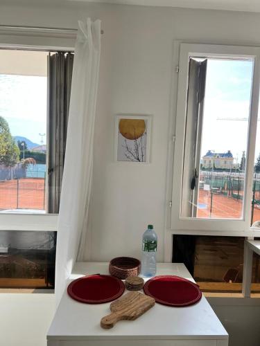 deux assiettes rouges sur un comptoir avec deux fenêtres dans l'établissement Charmant Studio équipé à Nice, à Nice