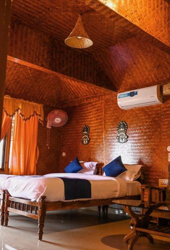 a bedroom with a large bed with blue pillows at Sajeev Home Stay in Cherai Beach