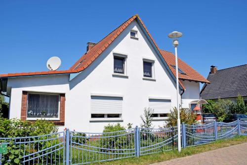 a white house with a blue fence at Ferienwohnungen in Baabe beim Fischer in Baabe