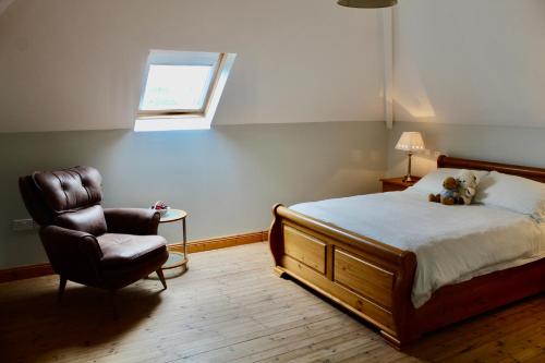 a bedroom with a bed and a chair and a window at Mount Leinster View in Bunclody