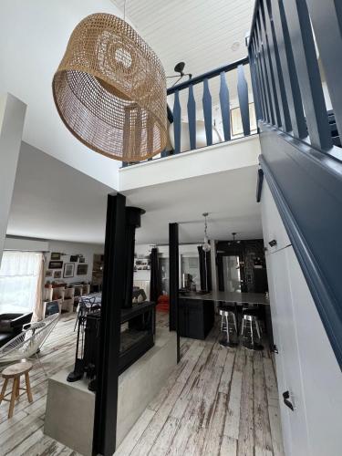 un salon avec un escalier et un lustre dans l'établissement Maison bord de mer, à Zuydcoote