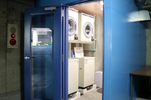 una puerta azul en una habitación con 2 lavadoras en Nagasaki IK Hotel, en Nagasaki