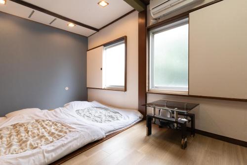 a small bedroom with a bed and a desk at Tokyo Guest House Ouji Music Lounge in Tokyo