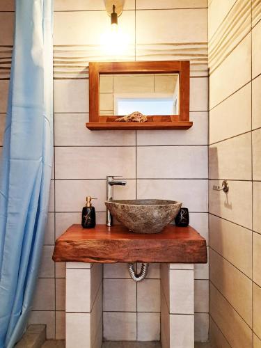 a bathroom with a stone sink and a mirror at Levanta Apartment in Kýthira