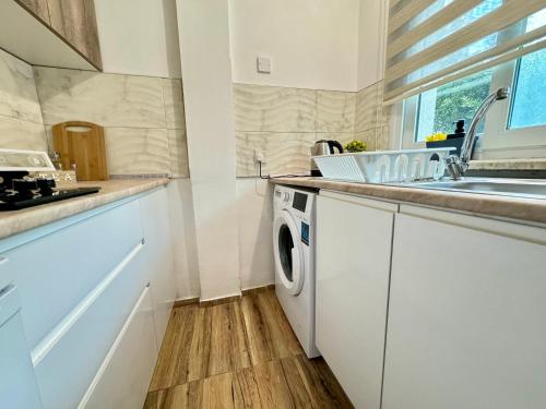 a white kitchen with a washing machine and a sink at Luxury Studios in Central Kyrenia in Kérynia