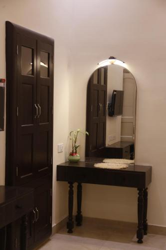 a bathroom with a black vanity and a mirror at HERITAGE HAVELI VARANASI in Varanasi