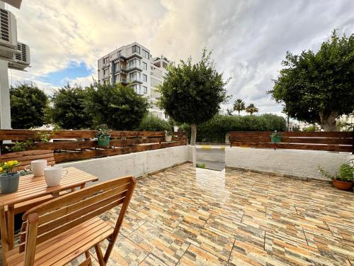 a patio with wooden benches and a building at Luxury Studios in Central Kyrenia in Kérynia