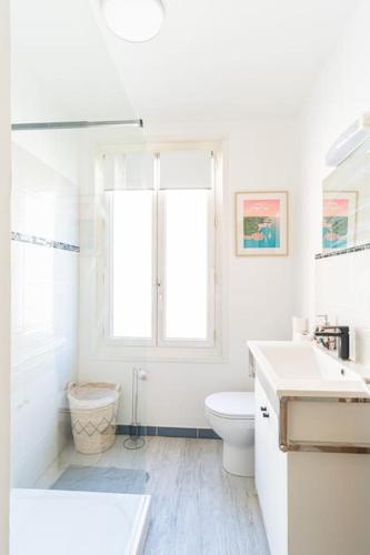 une salle de bain blanche avec des toilettes et un lavabo dans l'établissement Ô Terminus Océane - Proche gare - Lit King size, au Havre