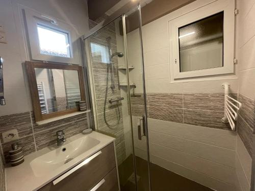 une salle de bain avec un lavabo et une douche en verre dans l'établissement Villa située entre mer et forêt, à Grand-Village-Plage