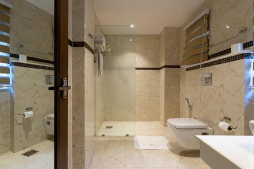 een badkamer met een douche, een toilet en een wastafel bij Meraki Holistic Wellness Retreat in Burhānilkantha