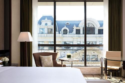 pokój hotelowy z łóżkiem i dużym oknem w obiekcie Courtyard by Marriott Shanghai Changfeng Park w Szanghaju