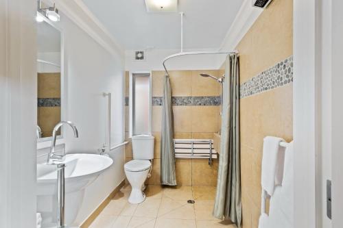 W łazience znajduje się toaleta, umywalka i prysznic. w obiekcie Tussock Peak Motor Lodge w mieście Hanmer Springs