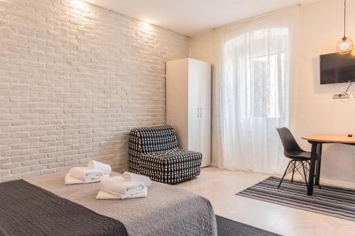 a room with a bed and a chair and a table at OLD TOWN PULA STUDIO APARTMENTS in Pula