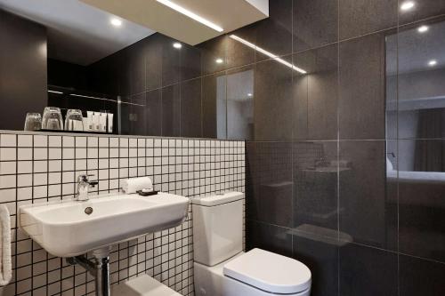 a bathroom with a toilet and a sink and a shower at Travelodge Hotel Auckland Wynyard Quarter in Auckland