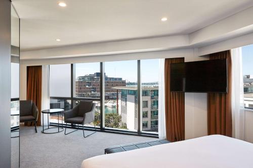 オークランドにあるTravelodge Hotel Auckland Wynyard Quarterのベッドと大きな窓が備わるホテルルームです。