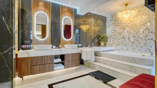 a bathroom with two sinks and a tub and mirrors at Imperia Luxury Residence in Braşov
