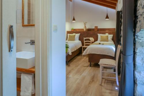 a bathroom with two beds and a sink in a room at Stanjel Retreat in Štanjel
