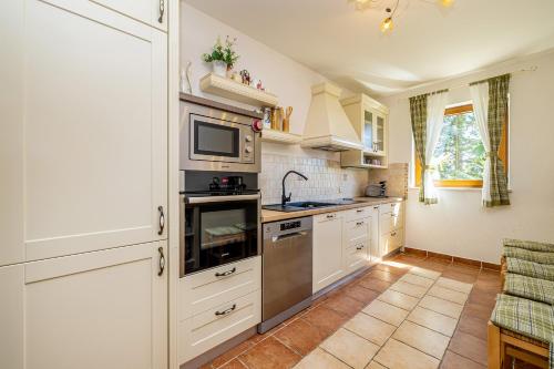 a kitchen with white cabinets and a stove top oven at Villa Rustica in Linardići
