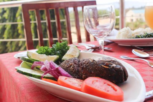 a plate of food with vegetables on a table at Flomi Hotel in Morogoro