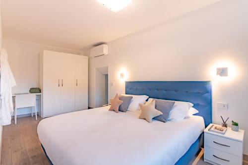 sypialnia z dużym łóżkiem z niebieskim zagłówkiem w obiekcie VILLA DEI VENTI - FOHN APARTMENT by Curtiaffitti w mieście Pianello Del Lario