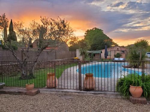 - une piscine avec des plantes en pot à côté d'une clôture dans l'établissement La haute verrerie, au Cannet-des-Maures